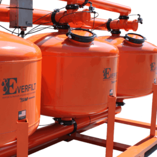 Three orange sand media filters for water treatment.